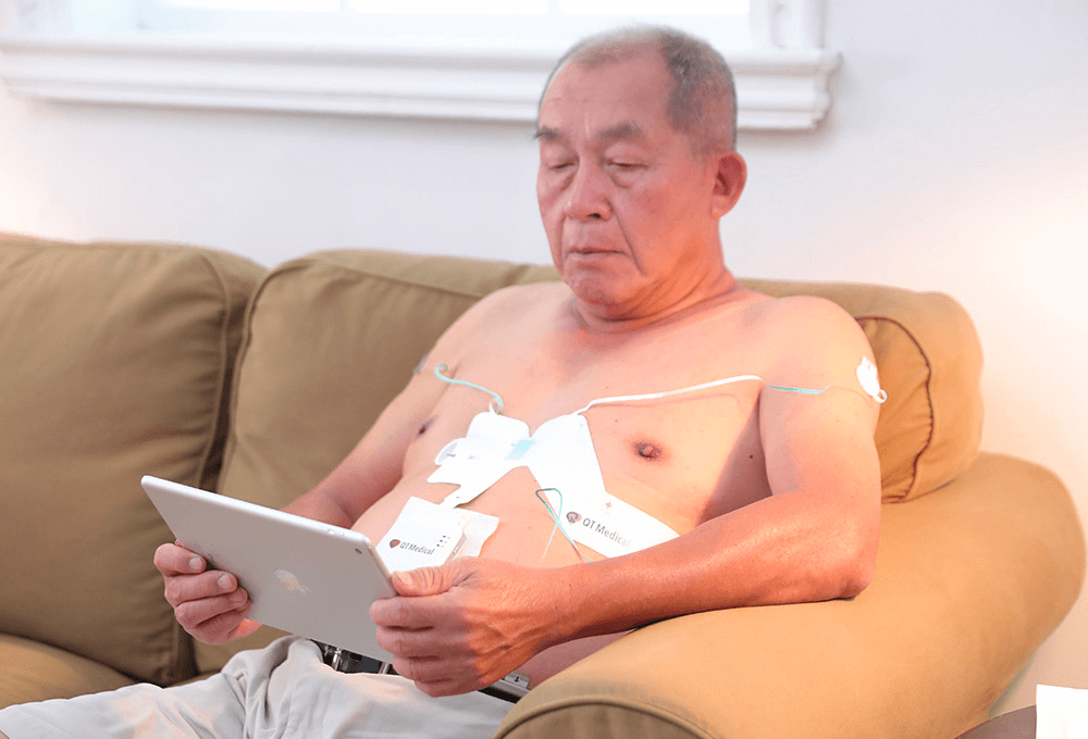 Elderly man using an ECG at home.