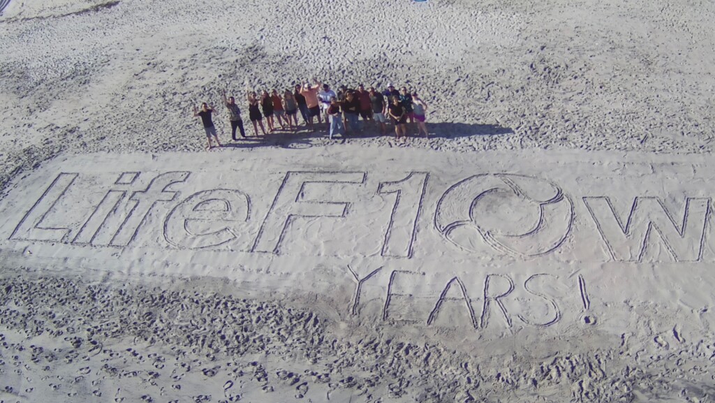 LifeFlow team on a beach celebrating ten years of the product.