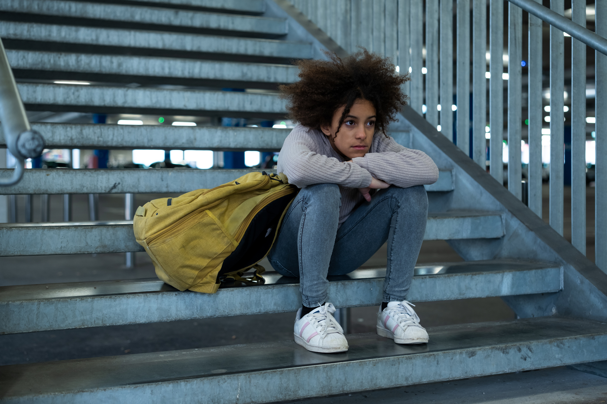 Sad girl sitting on stairs.