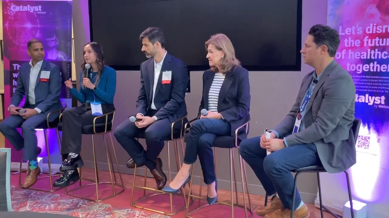 Panel of five people at a conference.