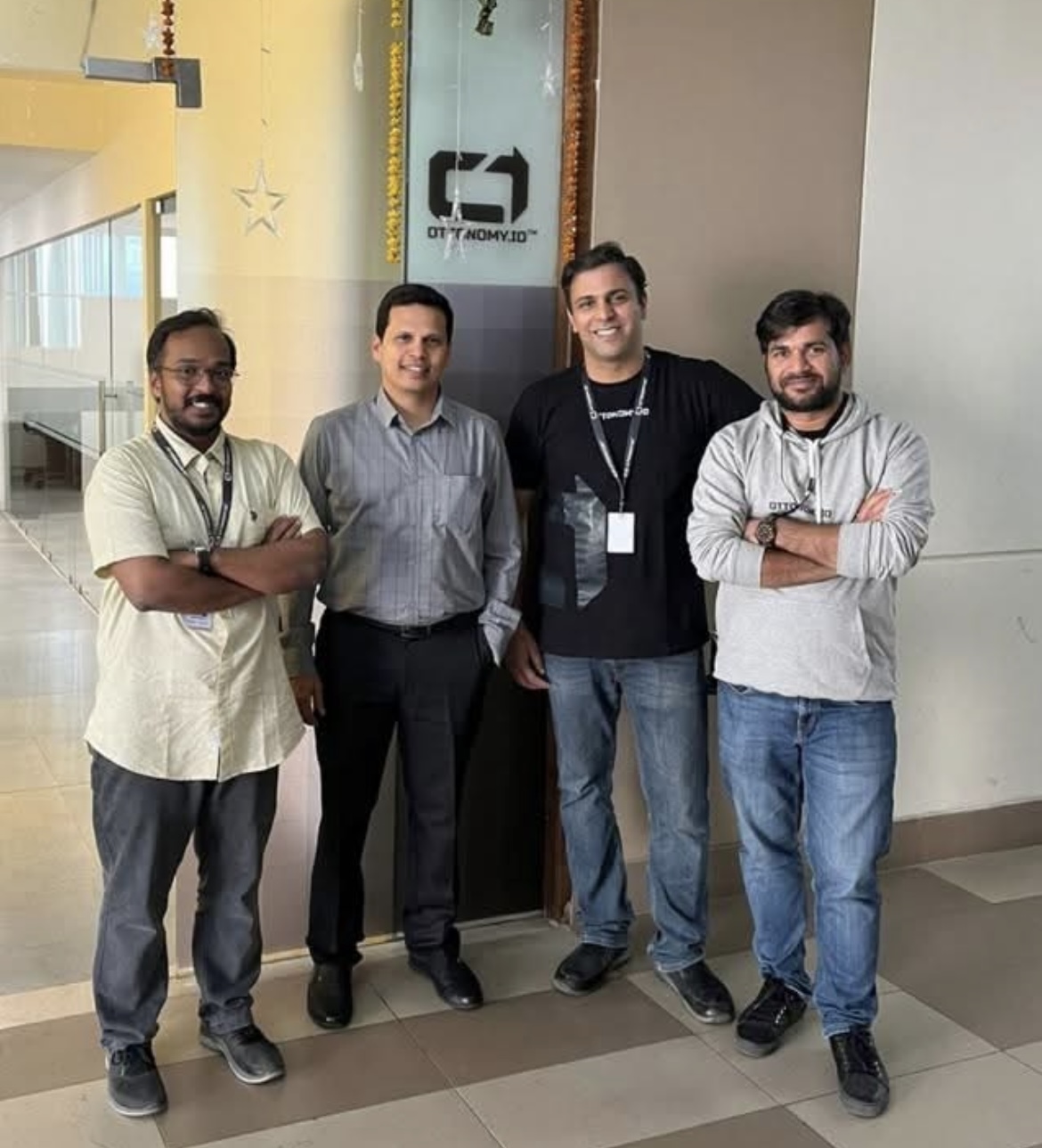 Four men on a hallway under the Ottonomy logo.