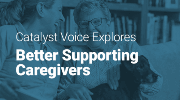 A mature woman sitting with her mother and pet dog on a sofa at home.