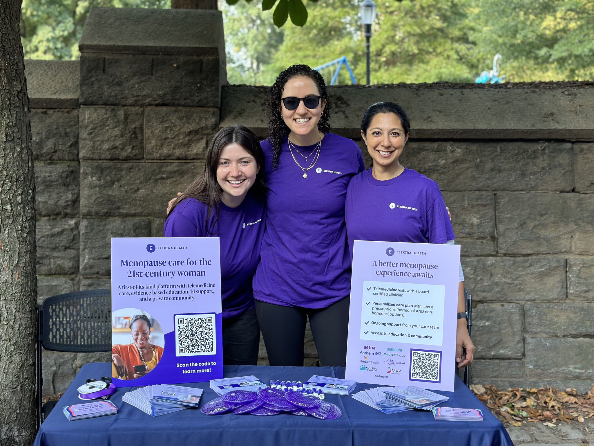 Three women at an Elektra table during an event.